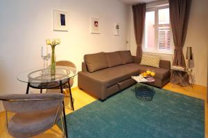 a living room with a couch and a glass table at Globe Apartament 2 in Zadar
