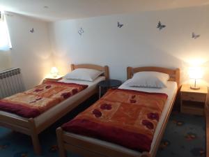 two beds in a small room with two lamps at Apartmani Kristanic in Karlovac
