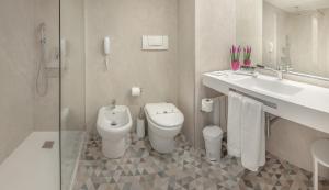 
a bathroom with a toilet a sink and a bathtub at Hotel RH Corona del Mar 4* Sup in Benidorm
