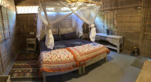 una camera da letto con un letto a baldacchino di Samsara Garden Resort a Morjim