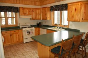 cocina con armarios de madera y encimera verde en Taylor Lake Point Condo, en Namekagon