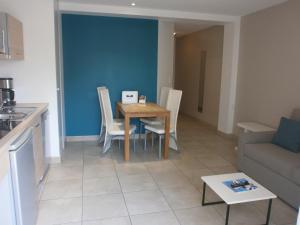 a living room with a table and chairs and a couch at Résidence Thalacap in Cap d'Agde