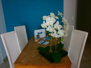 a table with a vase of white flowers on it at Résidence Thalacap in Cap d'Agde