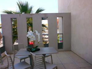 a patio with a table and chairs and some plants at Résidence Thalacap in Cap d'Agde