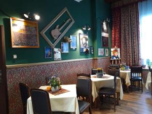 a dining room with tables and chairs and green walls at Willa Sorrento in Szczecin