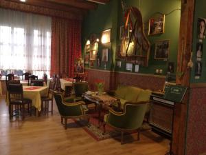 un restaurante con paredes verdes, sillas y mesas en Willa Sorrento, en Szczecin