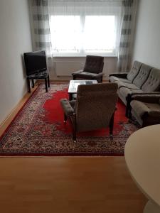 a living room with two couches and a red rug at Ruhige Ferienwohnung nahe Ostsee (30km) in Voigtsdorf/Nordvorpommern in Glewitz