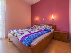 a bedroom with a bed and a red wall at Dolores in Crikvenica