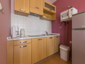 a small kitchen with wooden cabinets and a sink at Dolores in Crikvenica +51 photos