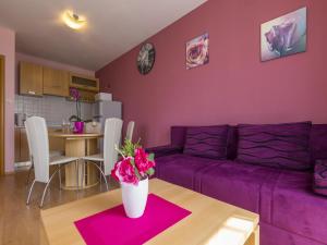 ein lila Wohnzimmer mit einem lila Sofa und einem Tisch in der Unterkunft Dolores in Crikvenica