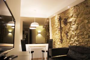 un soggiorno con parete in pietra, tavolo e sedie. di Almar Apartments a Póvoa de Varzim