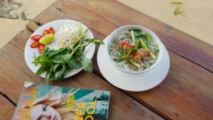 a table with a bowl of soup and a plate of food at Free Beach Resort in Phú Quốc