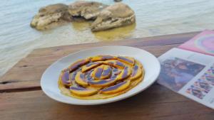 a white plate with a doughnut on a table at Free Beach Resort in Phú Quốc