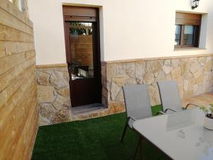 Habitación con 2 sillas y mesa con alfombra verde. en Apartamento La Sierra en La Codosera