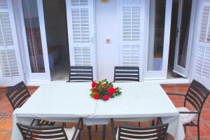 a white table with chairs and a flower arrangement on it at Monten in Sveti Stefan
