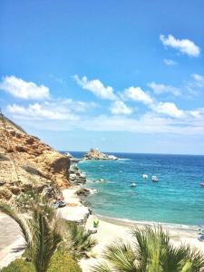 - une plage avec des personnes nageant dans l'océan dans l'établissement M&N Luxury Family Apartment 10meters from the Sea, à Agia Pelagia