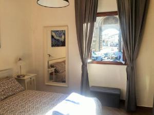 a bedroom with a bed and a window and a mirror at La casetta dipinta in Florence