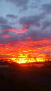 einen Sonnenuntergang mit Sonnenuntergang am Himmel in der Unterkunft Ferienwohnung mit Seeblick in Brandenburg an der Havel