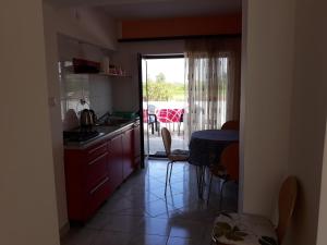 a kitchen with a sink and a table with a view of a patio at Apartmani Kristanic in Karlovac