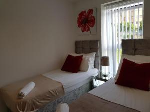 two beds in a room with a window at Vetrelax Basildon Newly refurbished 3bed House in Basildon