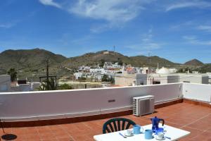 a balcony with a table and chairs and mountains at Casas Maria Carmona in El Pozo de los Frailes