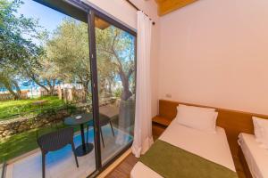 a bedroom with a window and a bed and a table at Alban Eco Hotel in Dhërmi
