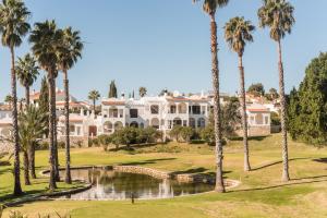 uma grande mansão branca com palmeiras e um lago em Casa Folkiño em Carvoeiro
