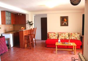 a living room with a red couch and a kitchen at Monten in Sveti Stefan