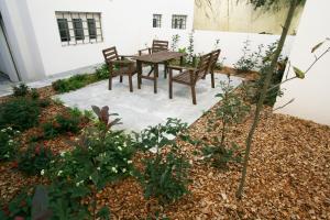 uma mesa de madeira e cadeiras num jardim em OPO.APT - Art Deco Apartments in Oporto's Center em Porto