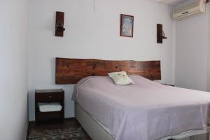 a bedroom with a white bed with a wooden headboard at Tuncay Pension in Selçuk