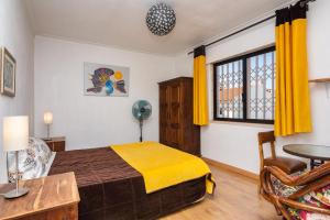 1 dormitorio con cama, mesa y ventana en Lisbon South Bay Rooms, en Amora