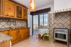 a kitchen with wooden cabinets and a table with chairs at Lisbon South Bay Rooms in Amora