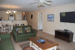 sala de estar con sofá verde y TV en Fairways At Riveroaks 23D Condo, en Myrtle Beach