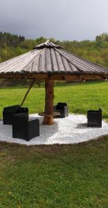 een paviljoen met een tafel en stoelen in een veld bij Agriturismo Fattoria Dalcastagnè in Torcegno