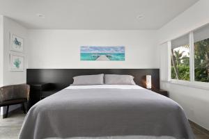 Un dormitorio blanco con una cama y una ventana. en Elizabeth House Inn, en Deerfield Beach