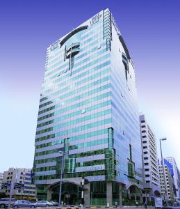 a large building with a large clock on top of it at Al Maha Arjaan by Rotana in Abu Dhabi