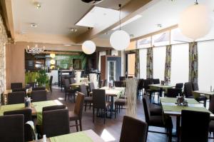 a dining room with tables and chairs and windows at Restaurant Gästehaus Seiger in Sankt Lorenzen bei Knittelfeld