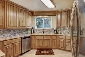 a kitchen with wooden cabinets and a window at Cri221 Cinnamon Ridge Condo in Keystone
