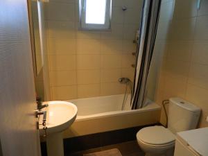 a bathroom with a toilet and a tub and a sink at Kalithies apartment in Kalithies +23 photos
