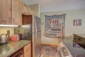 una cocina con nevera de acero inoxidable con un cartel en la pared en Fp114 Foxpine Inn Condo, en Copper Mountain