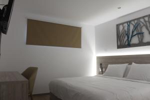 a bedroom with a white bed and white walls at Vallian Village Hotel in Paradeísion