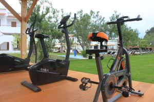 três bicicletas de exercício sentadas numa mesa de madeira num parque em Vallian Village Hotel em Paradeísion