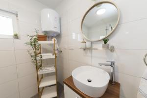 een badkamer met een wastafel en een spiegel bij Apartmani Zara in Zaton