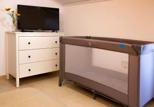 a tv and a dresser with a television and a dresser with a dress at A Casa dos Girassóis in Cuba