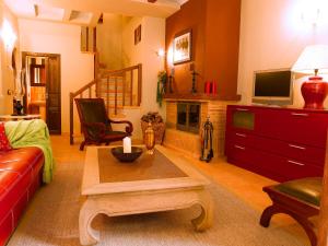 a living room with a red couch and a fireplace at Casa Miñón in Buera