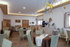 restauracja ze stołami i krzesłami w pokoju w obiekcie Garnì & Wellness Anderle w mieście Vignola