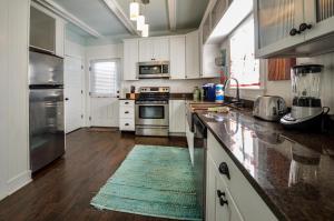a kitchen with white cabinets and a blue rug on the floor at The Rookery III Unit 7024 Cottage in Gulf Shores