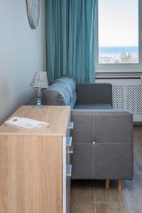 uma sala de estar com um sofá e uma mesa em Avis Apartments - Gdynia Skwer Kościuszki em Gdynia