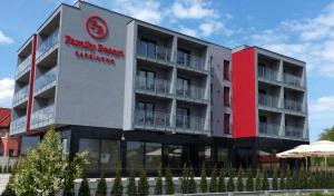 un edificio de apartamentos con fachada en rojo y blanco en Family Resort Sarbinowo, en Sarbinowo