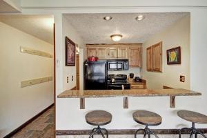 a kitchen with three bar stools and a counter top at Sf204 Snowflake Condo in Copper Mountain